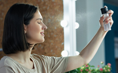 Canvas Print - Side view portrait of a young woman making makeup. Brunette female making an online tutorial with beauty product.