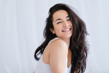 Smiling cheerful young girl in underwear sitting on the bed