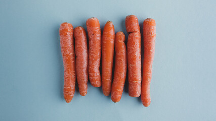 Wall Mural - orange food background. close-up of vertically carrots on blue. Bunch of orange organic carrots. natural vegetable food just harvested. colorful food