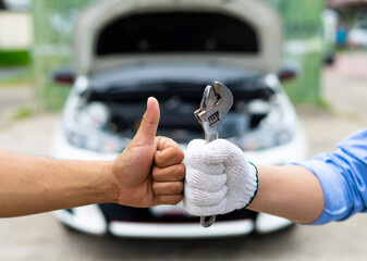 The male mechanic's hand holds the wrench Are showing solidarity with colleagues , Concept of engineer and auto repair