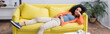 © LIGHTFIELD STUDIOS - bored african american woman chilling on yellow couch, banner