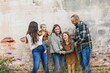 © Ursula Page - A family of five with two girls and a baby boy standing by an urban old brick wall and laughing