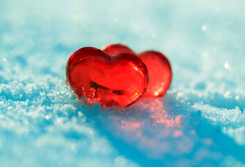 valentine's day greeting card with festive background with two transparent red love symbols hearts on blue snow