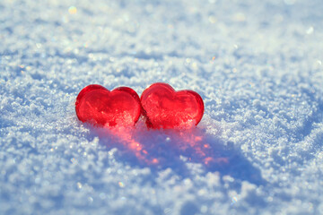 valentine's day greeting card with festive background with two transparent red love symbols hearts on the snow