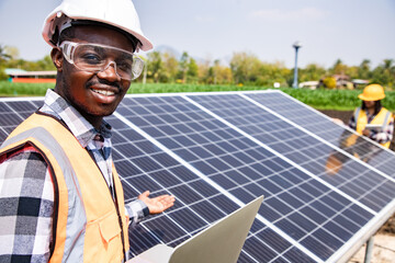 two workers technicians installing heavy solar photo voltaic panels to high steel platform in corn f