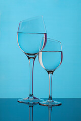 
Two beveled glass goblets on a blue background