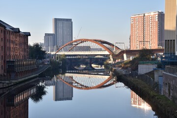 Canvas Print - Ordsall Chord bridge over the river Irwell in Manchester City centre with modern buildings and reflections in the water. 