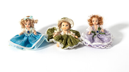 Three beautiful tiny vintage ceramic dolls dressed as princesses on a white background. Retro composition. 