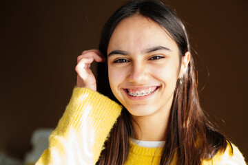 Cute and happy teen girl with braces smiling to camera