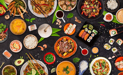 Wall Mural - Asian food served on black stone table, top view, space for text. Chinese and vietnamese cuisine set.