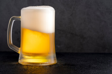 Cold beer with foam on black backgound