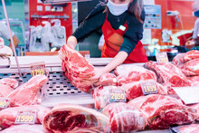 Butcher Woman Placing Meat On The Counter