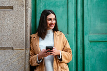 Young Stylish Woman Using A Smartphone On Urban Street
