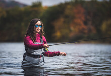 Woman Angler In Waders Strips Fly-line From Her Fly-rod While Fishing