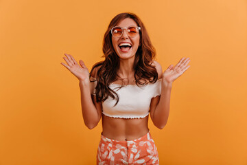 Canvas Print - Portrait of naughty brown-haired girl in trendy summer orange outfit. Lady with glasses posing with smile