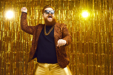 Happy funny bearded young man in crazy outfit dancing gangnam style and having fun on stage at disco nightclub party. Funky confident redhead chubby guy doing rope dance move like cowboy with lasso