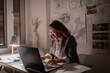 © Cavan Images - Smart businesswoman using laptop in dark office