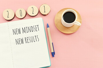 Poster - top view image of table with open notebook and the text new mindset new results. success and personal development concept