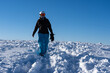 © Claudine - Female snowboarder walking in tracks in the snow on top of mountain Switzerland. Blue sky with copy space.