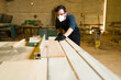 © AntonioDiaz - Hispanic man cutting wood with protective equipment