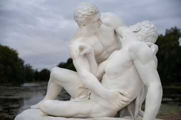 Wall Mural - Very old sculpture of a couple of men embracing in white marble