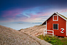 Red House On The Beach. Pink And Red Clouds Over The Sea. Swedish Landscape. Swedish House On The Rocks. Red Wooden House 