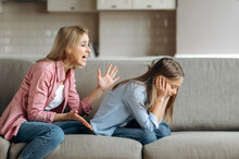 Angry Mother Scolding Little Daughter At Living Room, Parent Teaches A Naughty Mischievous Child, Kid Girl Feels Upset About Punishment And Deprivation Of Entertainment