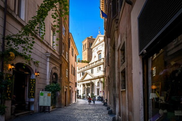 Wall Mural - Day view of a shaded alley and the Church of Sant' Eustachio with the head of a white stag holding it's cross in historic Rome, Italy.