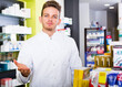 © JackF - Young man pharmacist wearing uniform and working in pharmaceutical shop