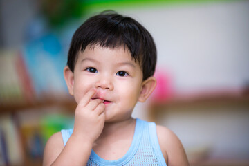 close-up. an asian boy uses his hand to eat food in his mouth. concept of health care, disease occur