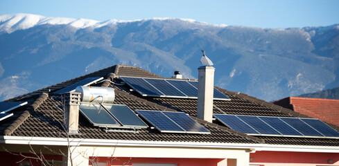 Canvas Print - solar panels on the roof of a house alternative energy green fir tree