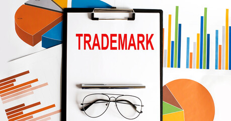 Poster - TRADEMARK . Conceptual background with chart ,papers, pen and glasses, business concept