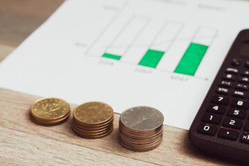 coins, calculator and bar graph on the table