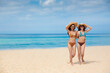 © Adulwit - Two happy women are sitting on the beach While relaxing on vacation for the weekend on sunny days and nice weather in travel and holiday concept.