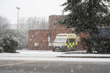 Ambulance Parked In Snow With Blanket Snowfall Under Tree NHS Under Pressure At Winter National Health Service Paramedic Vehicle Broken Down Alone