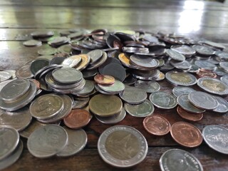 Many kinds of Thai coins on a wooden table