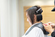 © garage38 - ヘアサロンで髪の毛をカットしてもらう若い女性