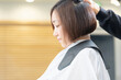 © garage38 - ヘアサロンで髪の毛をカットしてもらう若い女性