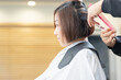 © garage38 - ヘアサロンで髪の毛をカットしてもらう若い女性
