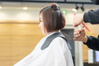 © garage38 - ヘアサロンで髪の毛をカットしてもらう若い女性