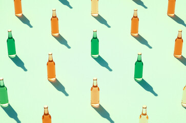 Leinwandbilder - Color glass bottles in rows against light blue/green surface.
