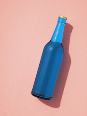 Leinwandbilder - Single blue beer bottle laying on pink background.