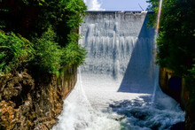 White Rushing Waterfall Over A Dam Wall From A Lake