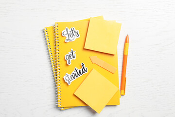 Canvas Print - Sheets of paper with phrase Let's Get Started and stationery on white table, flat lay