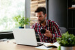 © JustLife - Young businessman using computer in his office. Handsome man on coffee break.