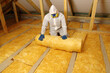 Worker in protective respirator insulating glass wool insulation