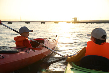 Poster - Little children kayaking on river, back view. Summer camp activity