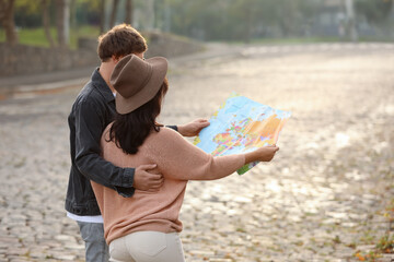 Canvas Print - Couple of travelers with map on city street