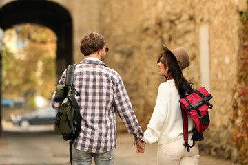 Canvas Print - Couple of travelers with backpacks on city street, back view