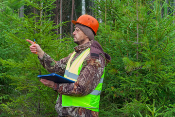 A forest ecologist oversees the development of a young forest. Real people work.